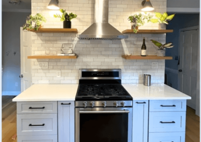 Modern kitchen with open wooden shelves, subway tile backsplash, stainless steel cooktop, updated cabinetry, and quartz countertops