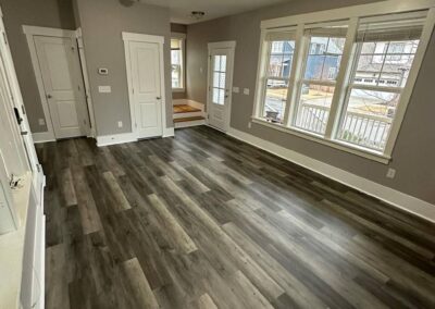 A room with newly installed luxury vinyl plank flooring in a gray tone, complemented by neutral wall paint, natural light, and clean trim, creating a modern and inviting atmosphere.