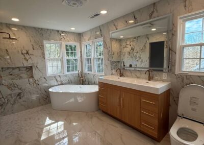 Luxurious bathroom with freestanding tub, double-sink vanity, and marble tile walls