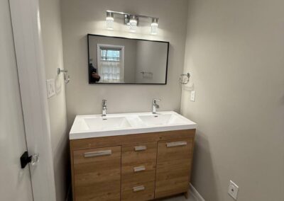 Modern double-sink bathroom vanity with wood finish and wall-mounted mirror