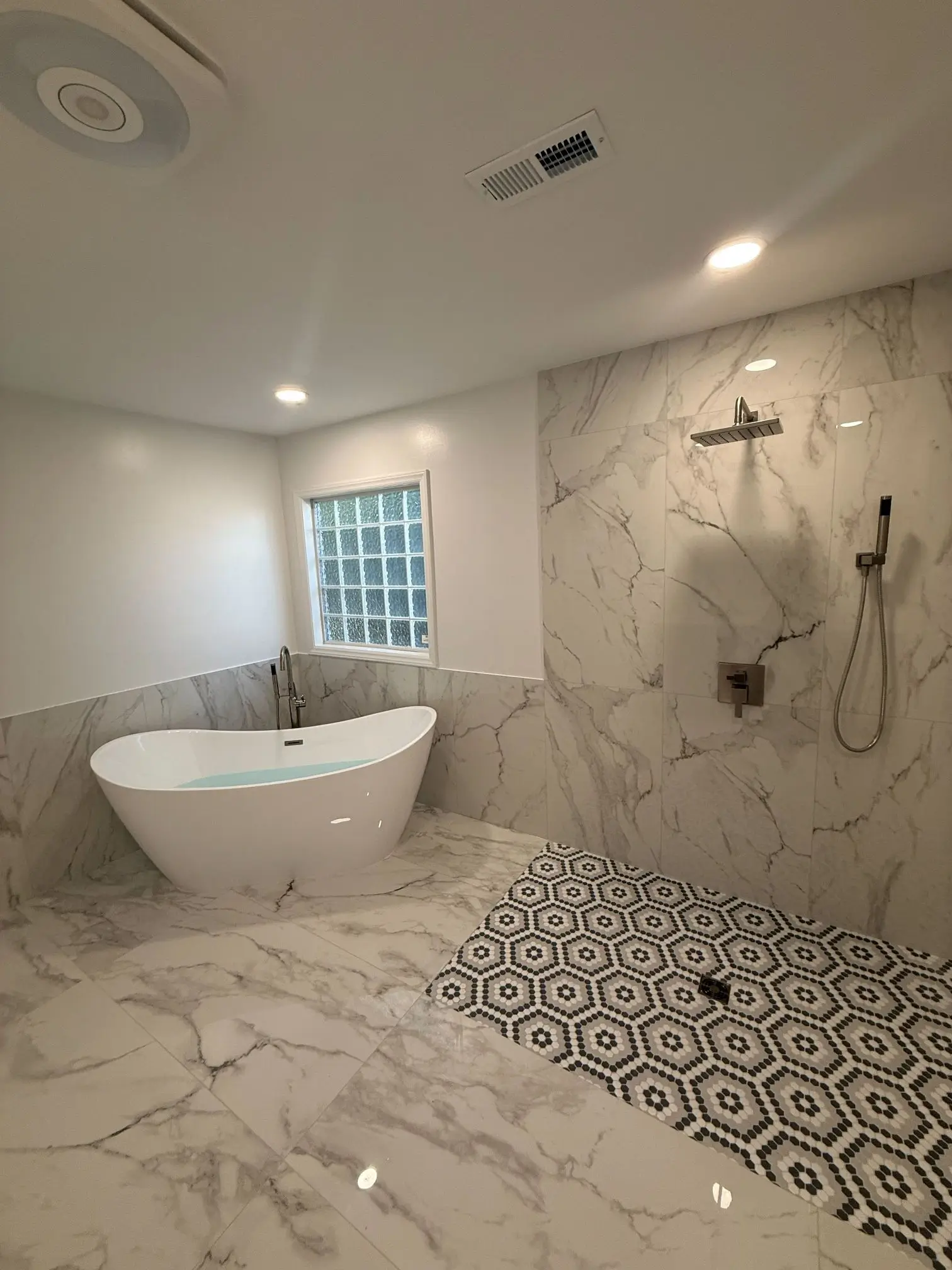 Luxury bathroom remodel with freestanding tub and marble shower walls