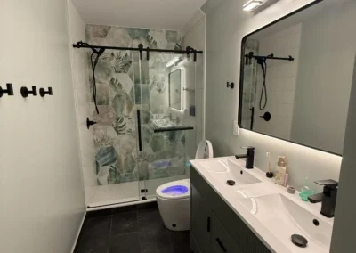 Bathroom remodel with double sink vanity and dark tile floor