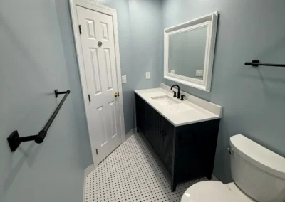 Minimalist bathroom remodeling with dark vanity and modern mirror