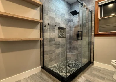 Custom walk in shower remodel with glass enclosure and shelving
