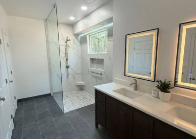 Contemporary bathroom remodel with dark floor tiles and double vanity