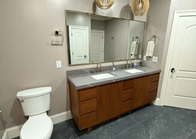 Modern bathroom remodeling with wood vanity and large mirror
