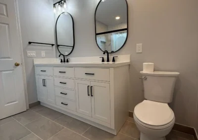 Small bathroom remodel with white vanity and round mirrors